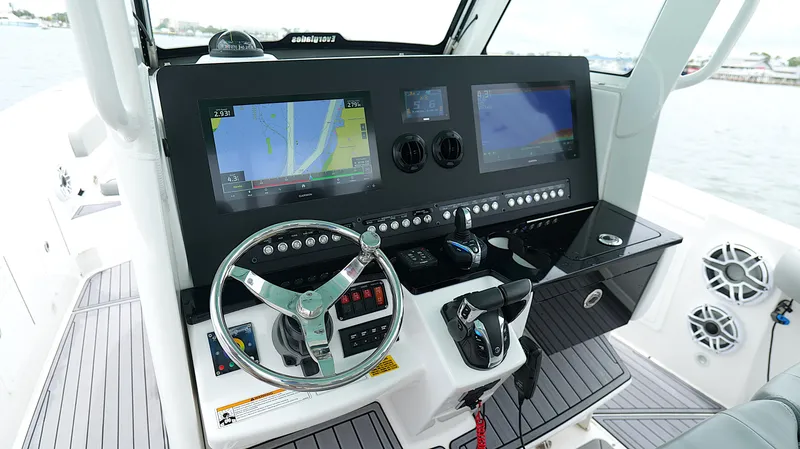 Slide: The Image of Control panel of 2023 Everglades 365 CC boat with navigation screens and steering wheel. - 13
