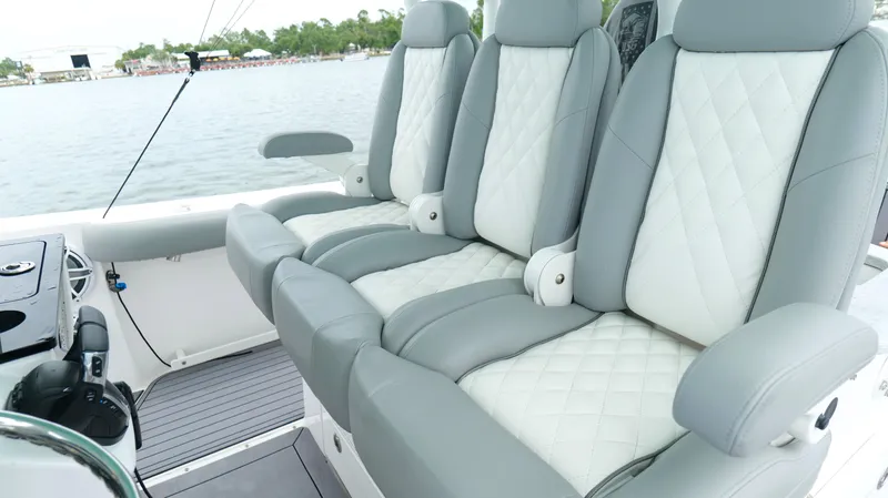 Slide: The Image of Luxurious seating on 2023 Everglades 365 CC boat, featuring quilted upholstery and armrests. - 19