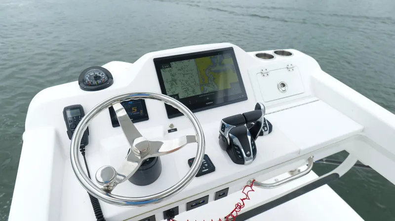 Slide: The Image of Control panel of 2023 Everglades 365 CC boat with steering wheel and navigation display. - 21