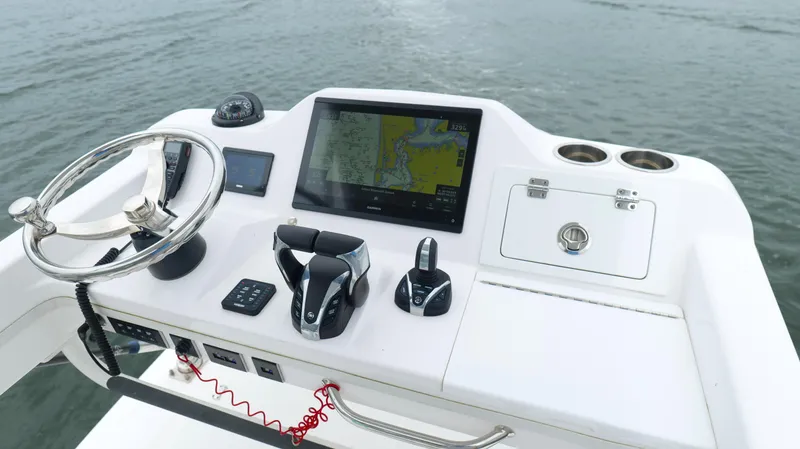 Slide: The Image of 2023 Everglades 365 CC boat helm with navigation system and controls on water. - 22