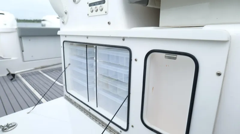 Slide: The Image of 2023 Everglades 365 CC boat storage compartments with organized tackle boxes. - 37