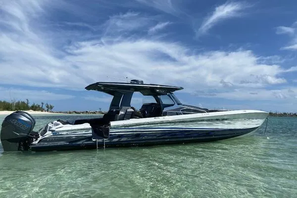 Slide: The Image of 2019 Nor-Tech 450 Sport Center Console boat in clear shallow water under a blue sky. - 0