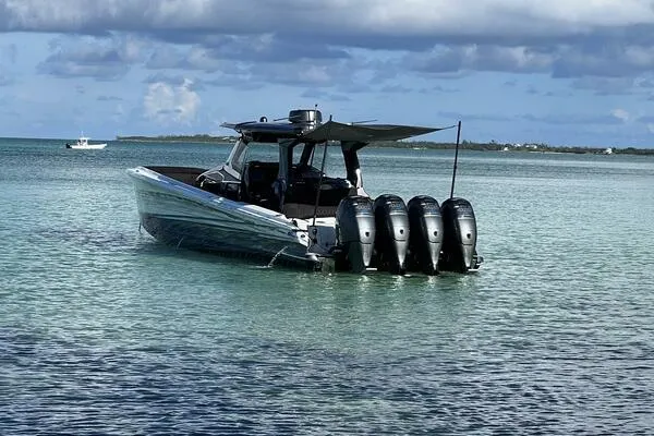 Slide: The Image of 2019 Nor-Tech 450 Sport Center Console boat with four engines on calm water. - 1
