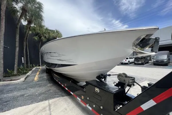Slide: The Image of 2019 Nor-Tech 450 Sport Center Console boat on trailer, parked near palm trees. - 4
