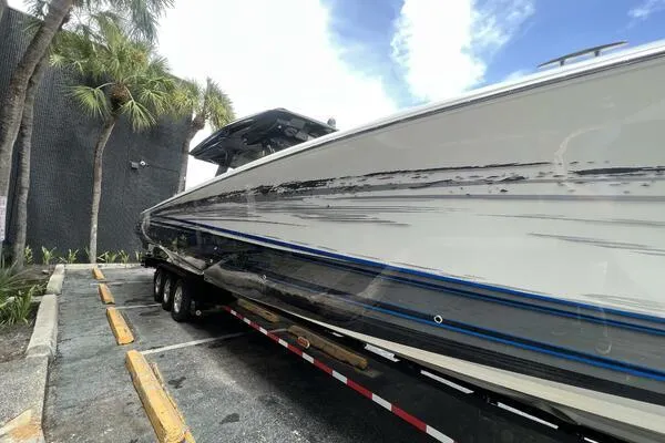 Slide: The Image of 2019 Nor-Tech 450 Sport Center Console boat on trailer, parked near palm trees. - 5