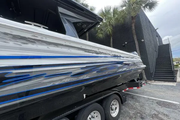 Slide: The Image of 2019 Nor-Tech 450 Sport Center Console boat with sleek design and blue accents, parked outdoors. - 7