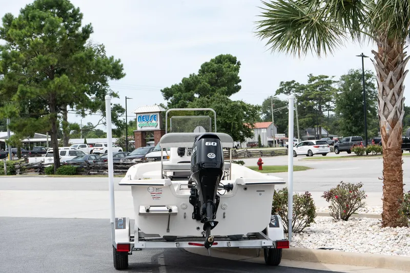 Slide: The Image of 2025 Carolina Skiff E16 JVX CC boat on trailer, parked near palm trees. - 3