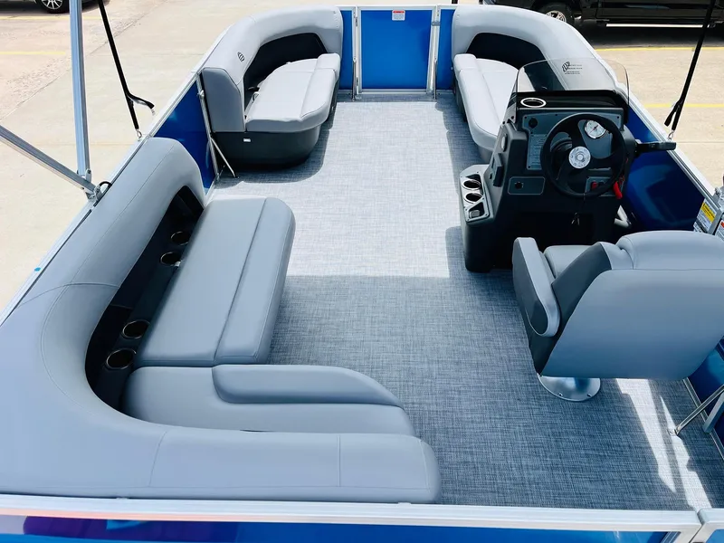 Slide: The Image of 2026 Sun Tracker Party Barge 16 DLX interior with gray seating and steering console. - 14