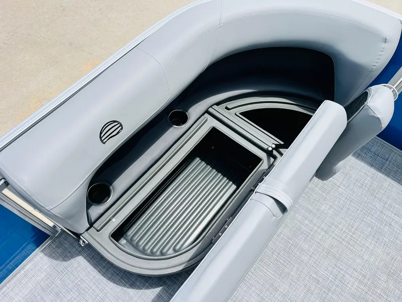 Slide: The Image of 2026 Sun Tracker Party Barge 16 DLX interior storage compartment with cup holders and cushioned seating. - 20