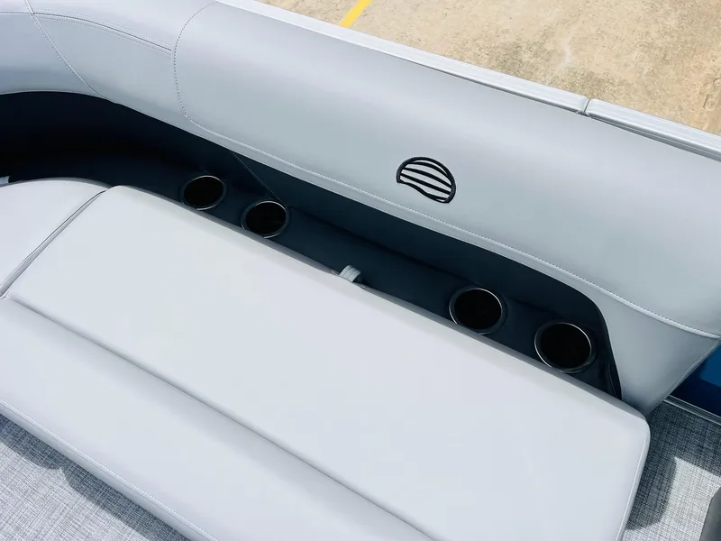 Slide: The Image of 2026 Sun Tracker Party Barge 16 DLX seating with cup holders and logo detail. - 22