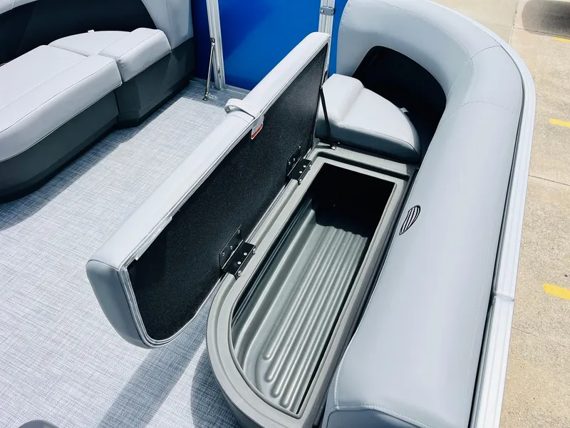 Slide: The Image of 2026 Sun Tracker Party Barge 16 DLX with open storage compartment and gray seating. - 23