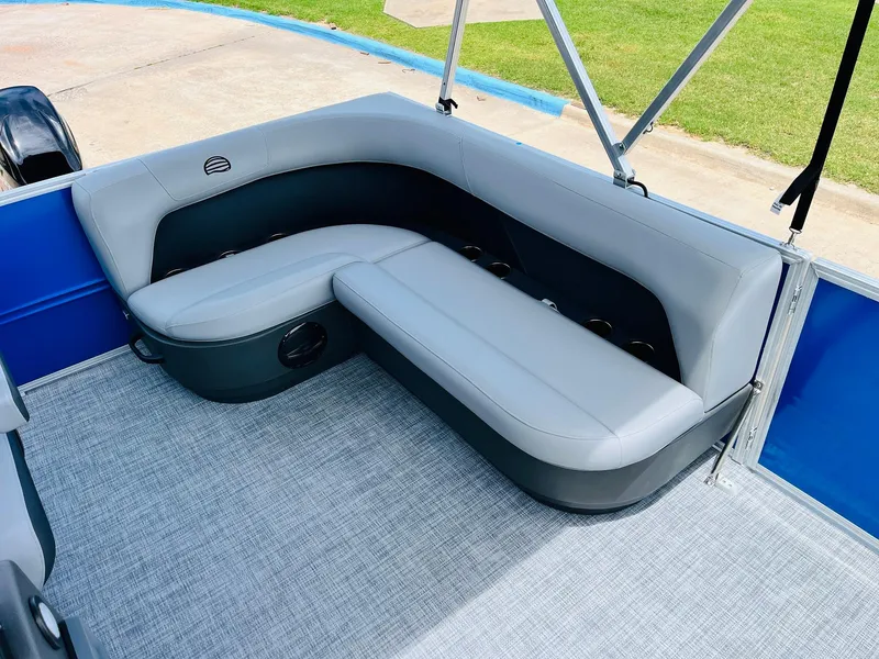 Slide: The Image of 2026 Sun Tracker Party Barge 16 DLX interior with gray seating and blue accents. - 26