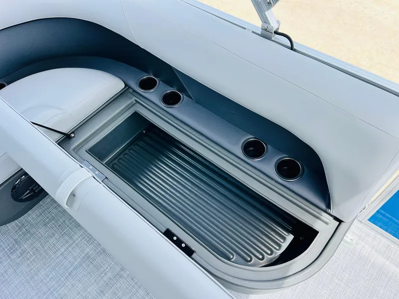 Slide: The Image of 2026 Sun Tracker Party Barge 16 DLX interior with storage compartment and cup holders. - 29