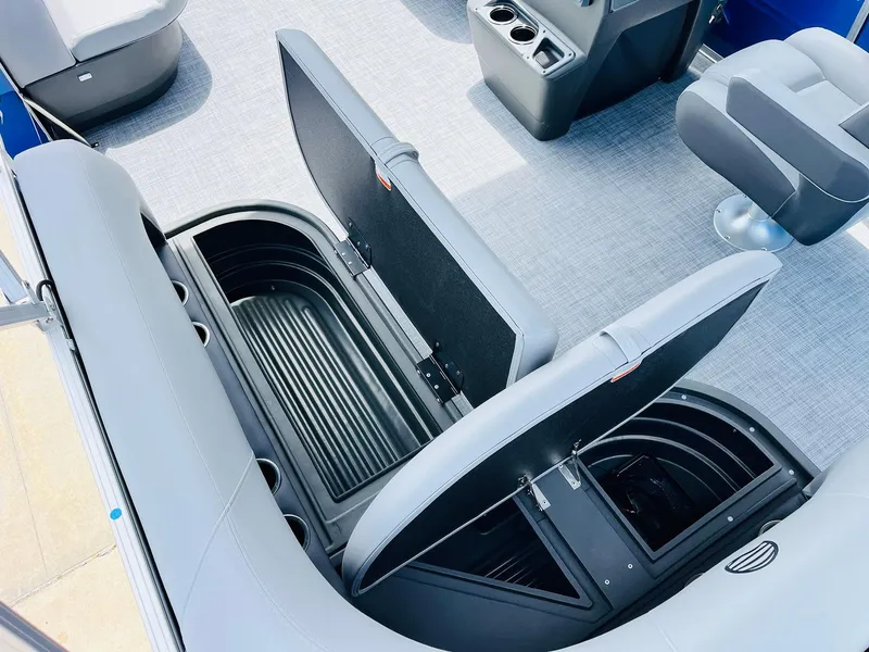 Slide: The Image of 2026 Sun Tracker Party Barge 16 DLX interior with open storage compartments and seating. - 31