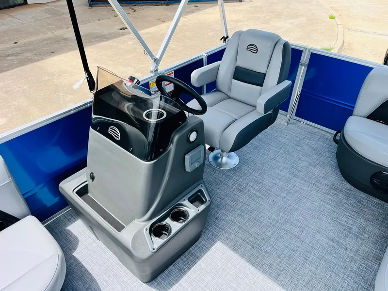 Slide: The Image of 2026 Sun Tracker Party Barge 16 DLX interior with captain's chair and steering console. - 32