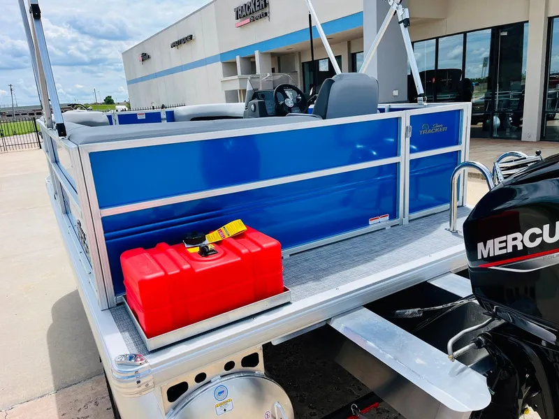 Slide: The Image of 2026 Sun Tracker Party Barge 16 DLX with Mercury engine, displayed outside dealership. - 9