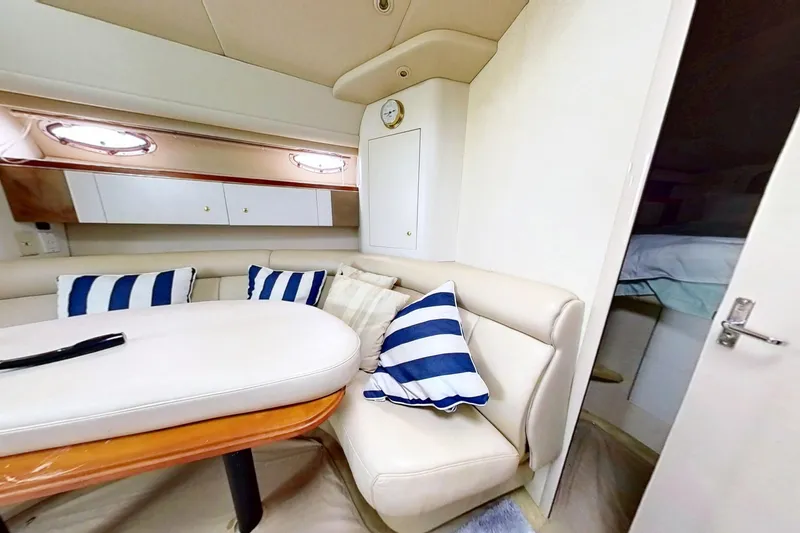 Slide: The Image of Interior of 1998 Cruisers Yachts 4270 Express with striped cushions and cozy seating area. - 11