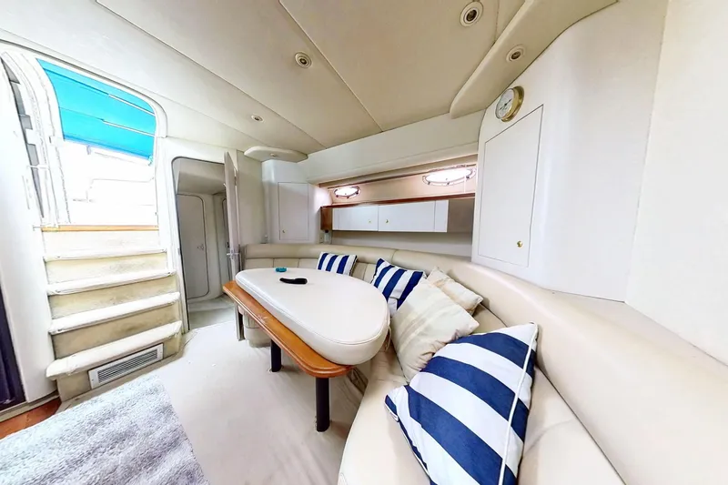 Slide: The Image of 1998 Cruisers Yachts 4270 Express interior with cozy seating and nautical decor. - 15