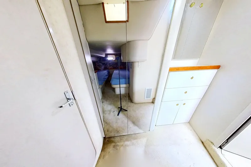 Slide: The Image of Interior of 1998 Cruisers Yachts 4270 Express, featuring mirrored closet and white cabinetry. - 19