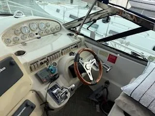 Slide: The Image of 1998 Cruisers Yachts 4270 Express cockpit with steering wheel and control panel. - 2