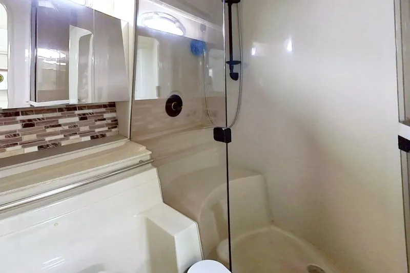 Slide: The Image of Bathroom interior of 1998 Cruisers Yachts 4270 Express with modern shower and tile accents. - 21