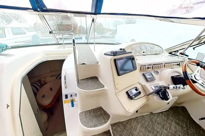 Slide: The Image of 1998 Cruisers Yachts 4270 Express helm with navigation equipment and cabin entrance. - 24