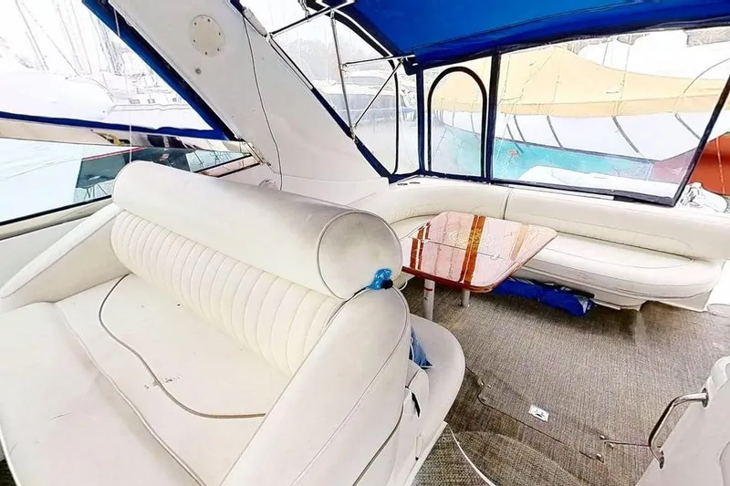 Slide: The Image of 1998 Cruisers Yachts 4270 Express interior with white seating and wooden table. - 28