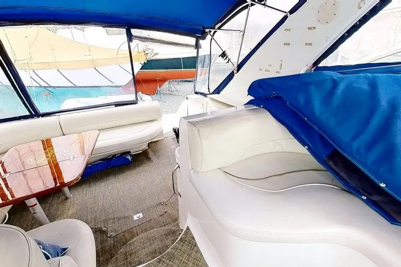 Slide: The Image of Interior of 1998 Cruisers Yachts 4270 Express with white seating and blue canopy. - 29