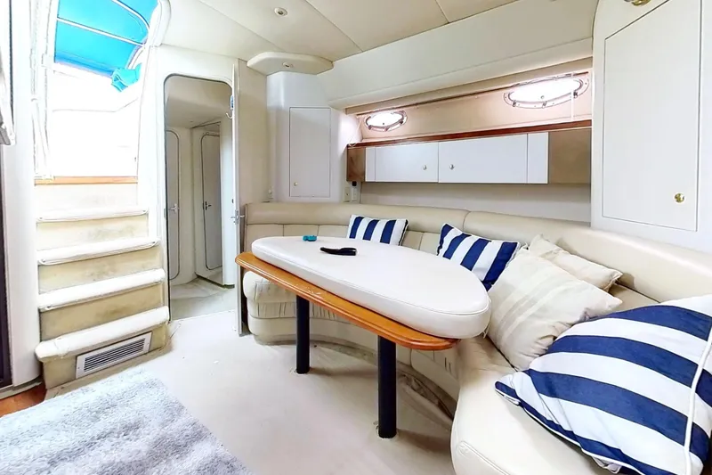 Slide: The Image of Luxurious interior of 1998 Cruisers Yachts 4270 Express with plush seating and striped cushions. - 3