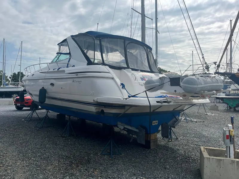 Slide: The Image of 1998 Cruisers Yachts 4270 Express on stands in a boatyard, under cloudy sky. - 32