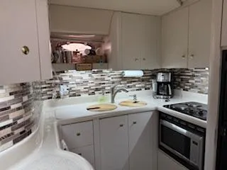 Slide: The Image of 1998 Cruisers Yachts 4270 Express kitchen with modern appliances and stylish backsplash. - 5
