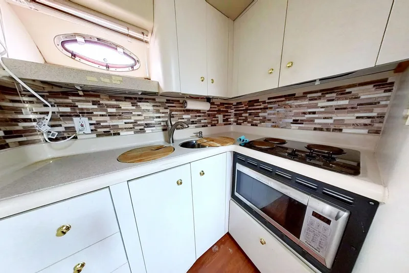 Slide: The Image of 1998 Cruisers Yachts 4270 Express kitchen with modern appliances and stylish backsplash. - 6