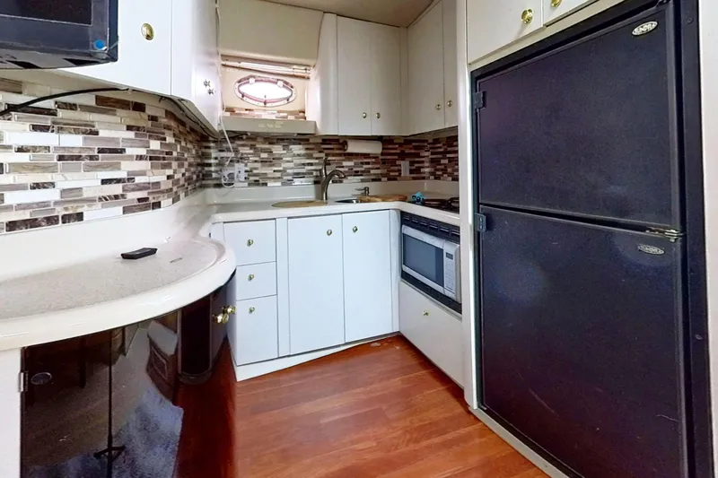 Slide: The Image of 1998 Cruisers Yachts 4270 Express kitchen with modern appliances and stylish backsplash. - 7