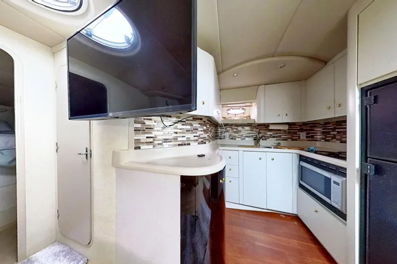 Slide: The Image of 1998 Cruisers Yachts 4270 Express interior kitchen with modern appliances and stylish cabinetry. - 9