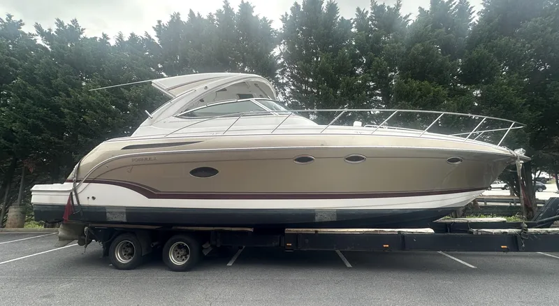 Slide: The Image of 2013 Formula 37 PC yacht on trailer, parked in a lot with trees in the background. - 30