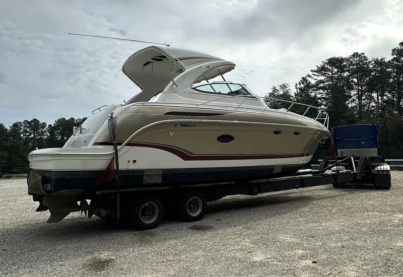 Slide: The Image of 2013 Formula 37 PC yacht on trailer, parked outdoors under cloudy sky. - 32