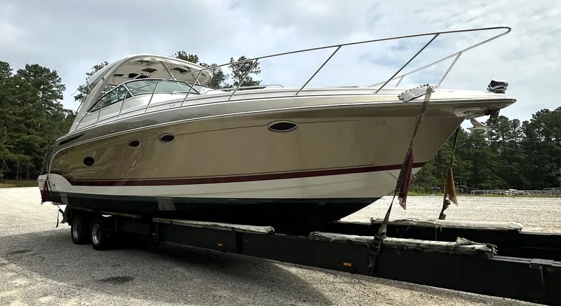 Slide: The Image of 2013 Formula 37 PC yacht on trailer, parked outdoors, surrounded by trees. - 33