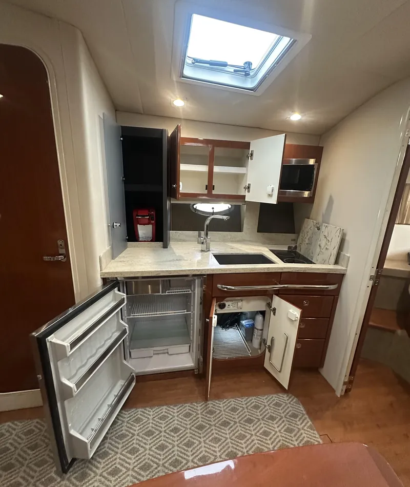 Slide: The Image of 2013 Formula 37 PC yacht kitchen with open cabinets, fridge, and modern appliances. - 8