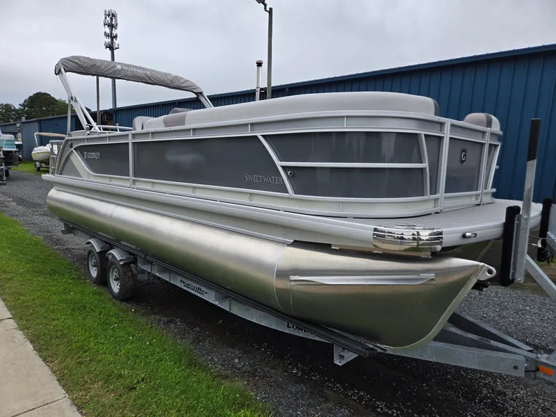 The Image of 2026 Godfrey SWEETWATER Entertainment 2486 DT pontoon boat on trailer, parked outdoors. - 0