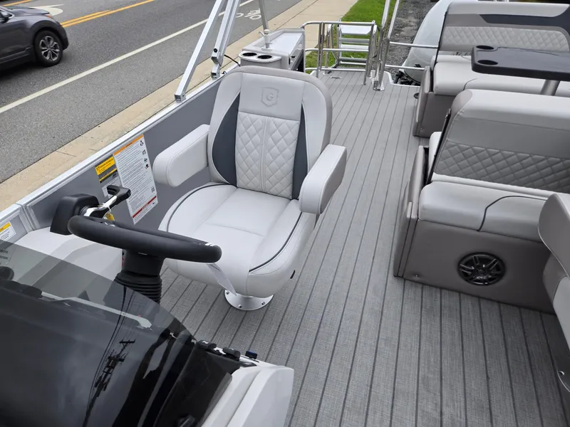 Slide: The Image of 2026 Godfrey SWEETWATER Entertainment 2486 DT boat interior with luxurious seating and steering wheel. - 13