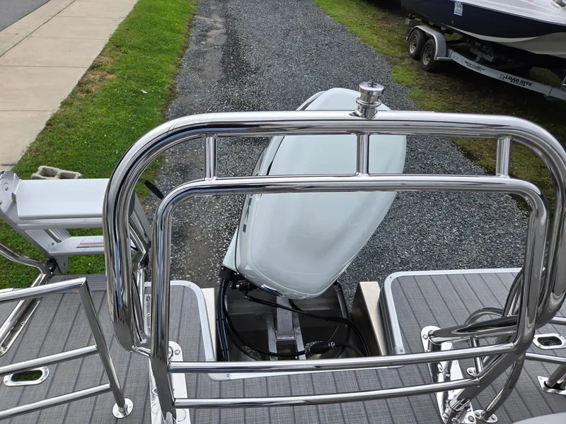 Slide: The Image of 2026 Godfrey SWEETWATER Entertainment 2486 DT boat with chrome railings and outboard motor. - 23