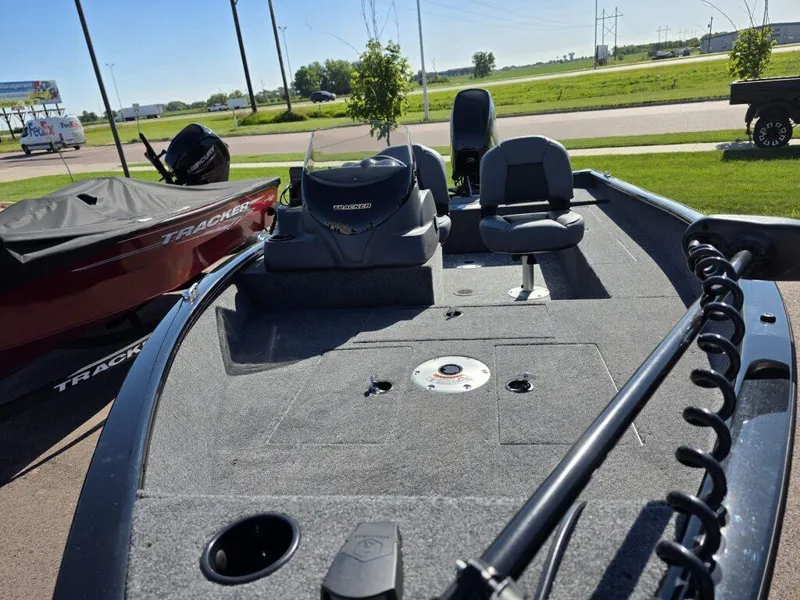 Slide: The Image of 2025 Tracker Super Guide V-16 SC boat with seating and motor, parked outdoors. - 8