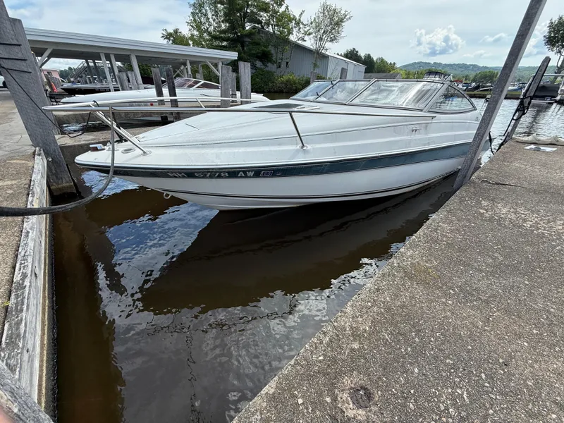 Slide: The Image of 1996 Doral 216 Cuddy boat docked at marina, calm water, overcast sky. - 13