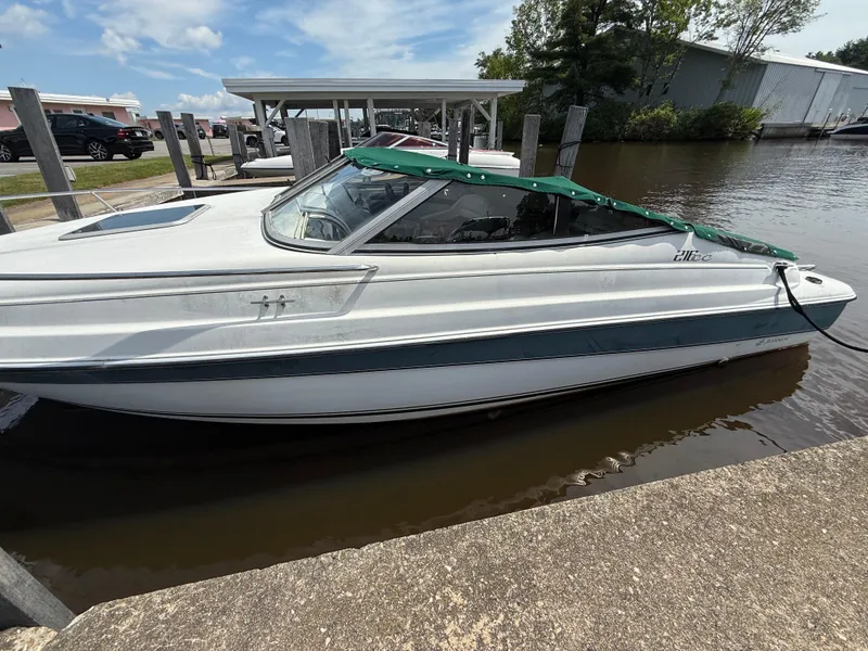Slide: The Image of 1996 Doral 216 Cuddy boat docked by the water, featuring a green canopy. - 3