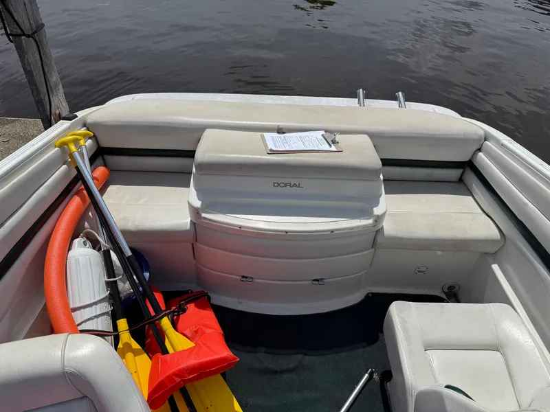 Slide: The Image of 1996 Doral 216 Cuddy boat interior with safety equipment and seating by the water. - 4