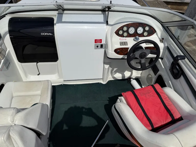 Slide: The Image of 1996 Doral 216 Cuddy boat interior with steering wheel and red life jacket. - 5