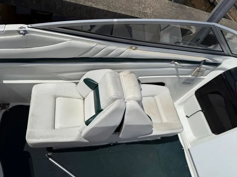 Slide: The Image of 1996 Doral 216 Cuddy boat interior with white seating and windshield. - 6
