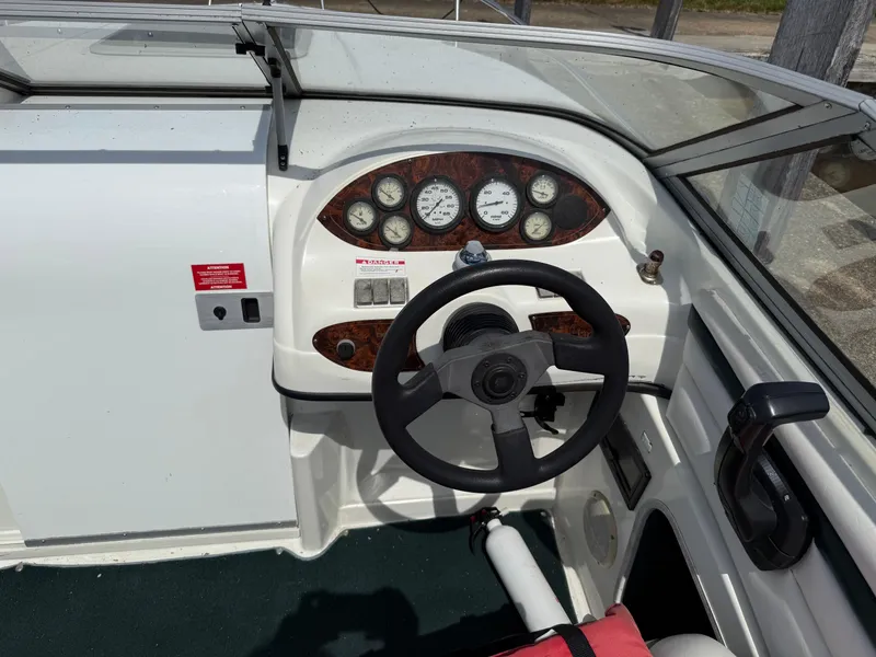 Slide: The Image of 1996 Doral 216 Cuddy boat dashboard with steering wheel and instrument panel. - 7