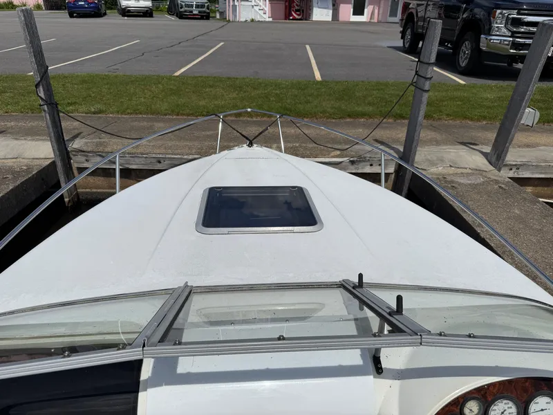 Slide: The Image of 1996 Doral 216 Cuddy boat docked, showing bow and windshield, with parking lot in background. - 8