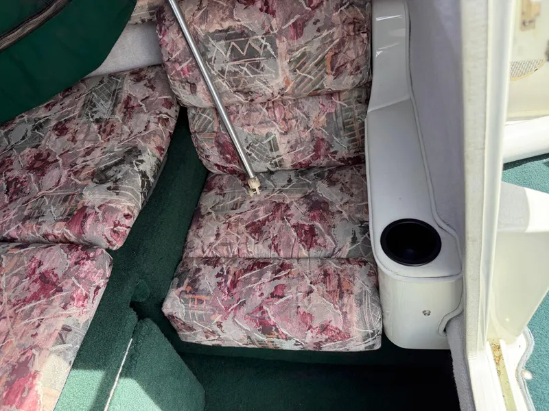 Slide: The Image of Interior of a 1996 Doral 216 Cuddy with patterned upholstery and cup holder. - 9